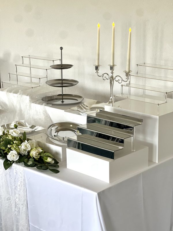 Buffet argenté et miroir avec escalier à desserts, chandelier et plateaux inox