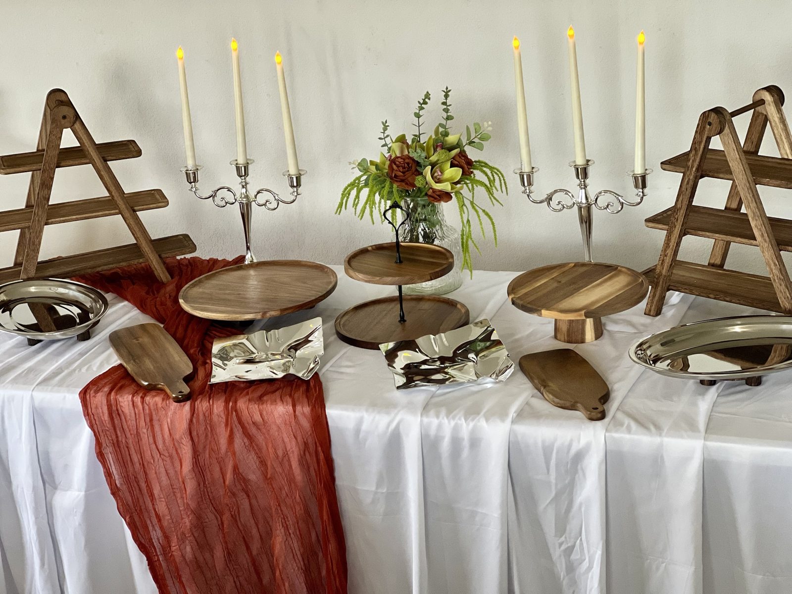 Buffet bois et argent dressé avec chandeliers, chemin de table terracotta et bouquet coordonné